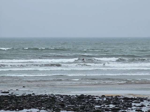Competition surfer finishing shoulder high wave in front of the shop